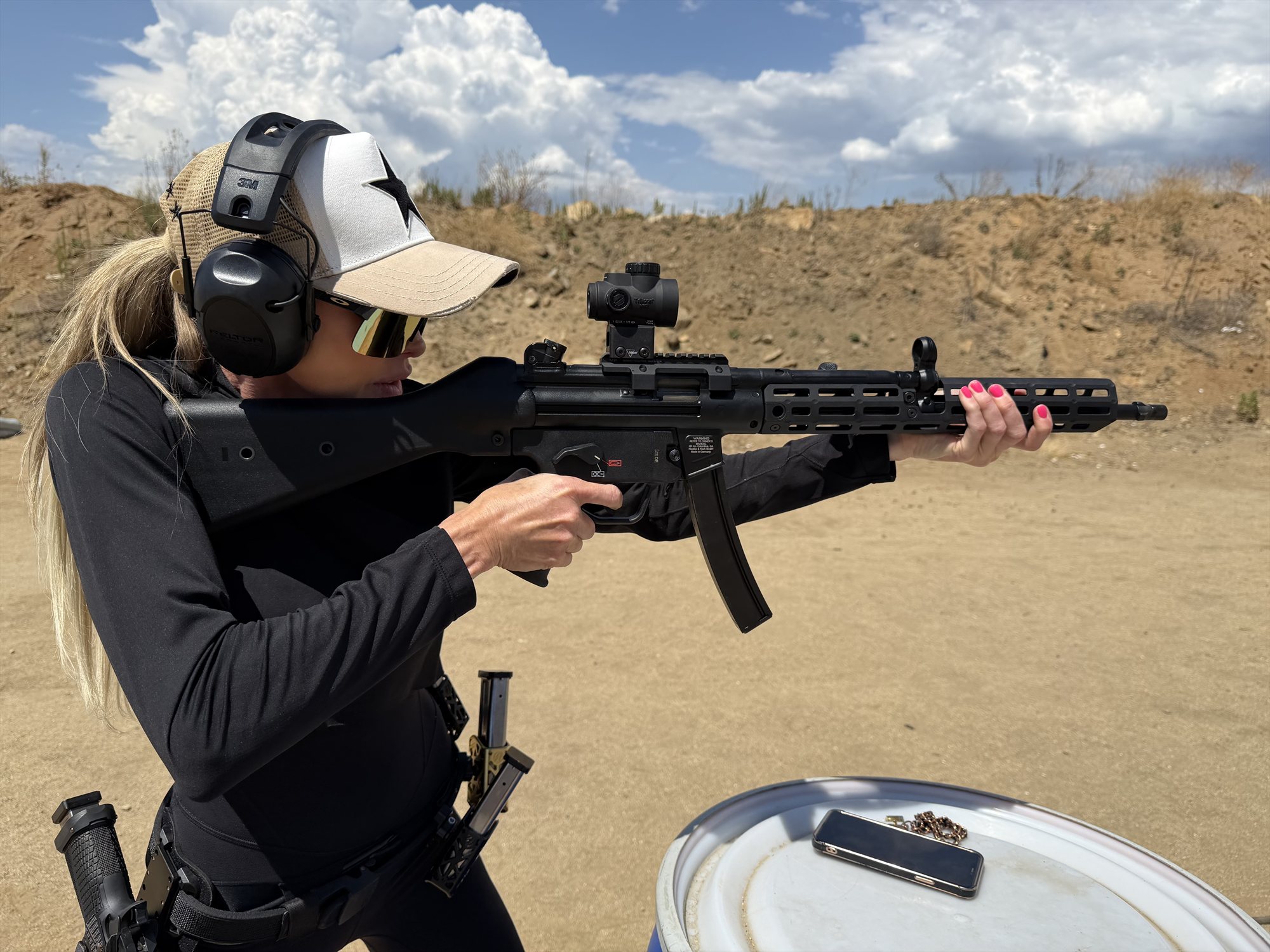 Jaclyn Lucia practicing at an outdoor range with eye and ear protection